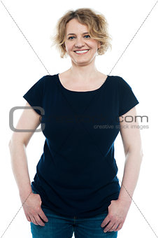 Casual aged woman posing with thumbs on pocket