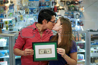 Happy Shop Owners kissing And Showing First Dollar