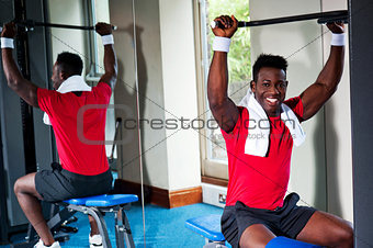 Confident young african guy working out in gym