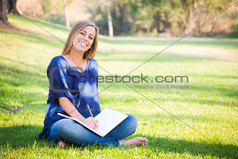 Portrait of a Beautiful Young Woman With Book Outdoors
