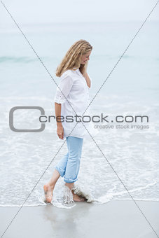 Smiling blonde walking by the sea