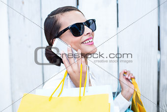 Pretty woman on the phone holding shopping bags