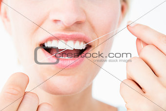 Pretty woman using dental floss