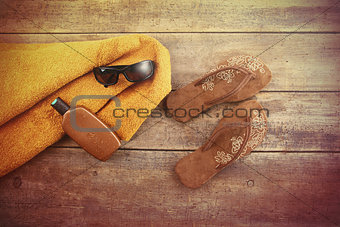 Orange towel and beach items on wood