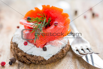 Sandwich with salted red salmon and black bread.