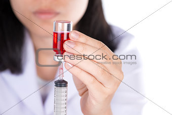 Closed up Nurse fills syringe from injection vial on white