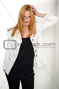 Beautiful young woman leaning against wall