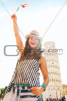 Happy woman tourist waving flag at Leaning Tower of Pisa