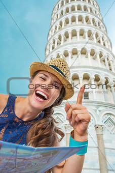 Happy woman tourist holding map and pointing at Tower of Pisa