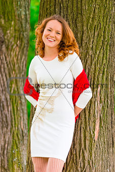 portrait of happy girl near old trees in the park