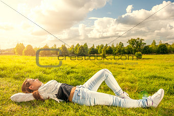 Beautiful teenager lying on the grass