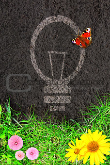 Eco background with green grass and light bulb silhouette 