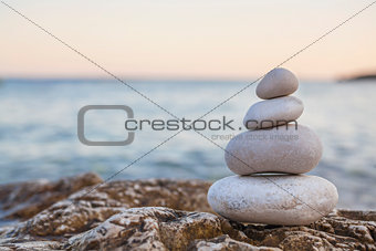 Pile of Stones on Tranquil Beach at Sunset