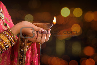 Close up Indian woman hands holding diya light