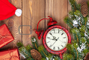 Christmas wooden background with clock, fir tree, gift boxes and