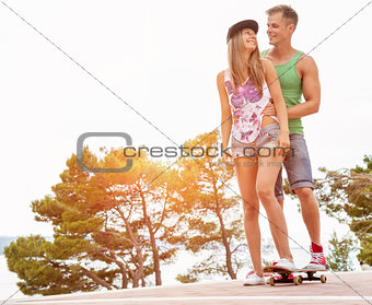 Young happy couple with a skateboard