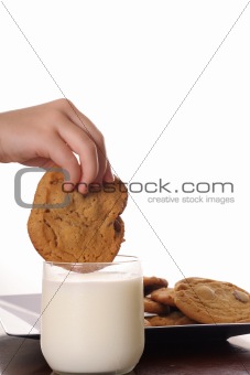 shot of dipping cookie in milk upclose vertical