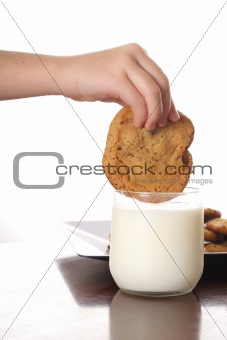 shot of dipping cookie in milk vertical