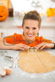 Woman cutting out Halloween cookies with pastry cutter