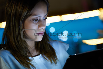 Latina Teenager Using Tablet PC Indoor At Night