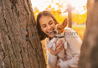 Portrait of young happy woman holding little cute dog