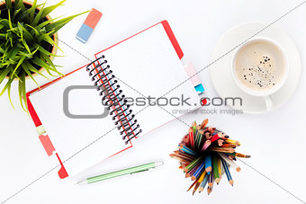 Office desk table with supplies, flower and coffee cup