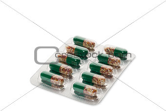 Green pills in a blister pack on white background