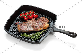 Sirloin steak with rosemary and cherry tomatoes cooking in a fry