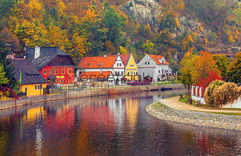 Autumnal landscape with coloured house over river