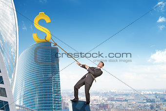 Businessman climbing skyscraper with dollar sign