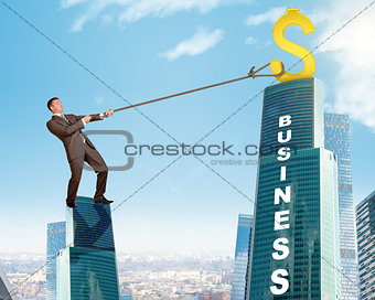 Businessman climbing skyscraper with word business