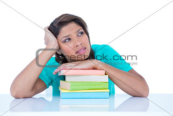 Thoughtful pretty brunette with hand on books