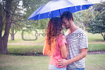 Cute couple hugging under the umbrella