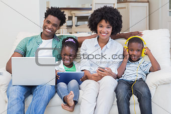 Happy family using technologies on the couch