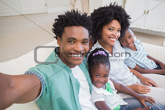 Happy family taking a selfie on the couch