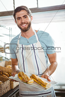 happy worker holding sandwiches