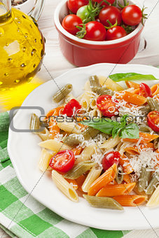 Colorful penne pasta with tomatoes and basil