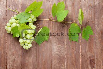 Bunch of grapes and vine on wooden table