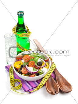 Fresh healthy salad, glass of water and kitchen utensil