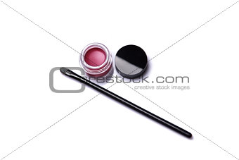 Red lip gloss in jar with makeup brush  