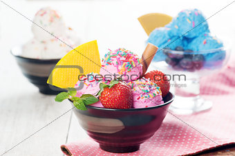 Pink, blue and white ice cream in bowl
