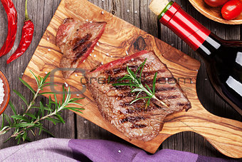 Grilled beef steak and red wine bottle
