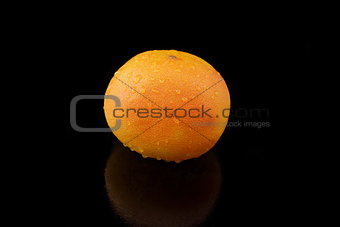 a grapefruit with drops of water on black background