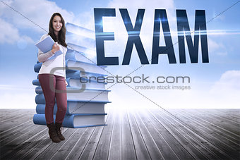 Exam against stack of books against sky