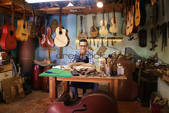 Portrait Of Happy Artisan Lute Maker In Guitar Shop Smiling At C