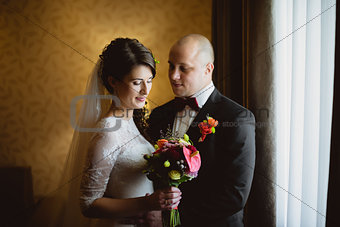 Bride and groom sitting at the window in room