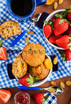 Breakfast with muffins, jam, coffee and strawberry
