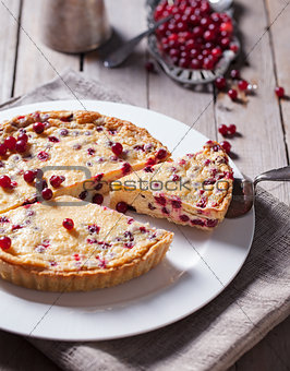 White chocolate cheesecake tart with cranberries on a white plate