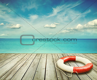 Wood pier with ocean and life preserver