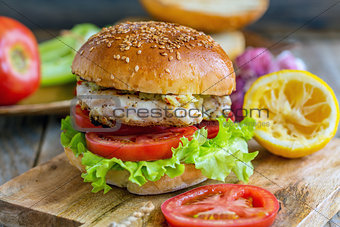 Burger with vegetables, chicken and spicy sauce.